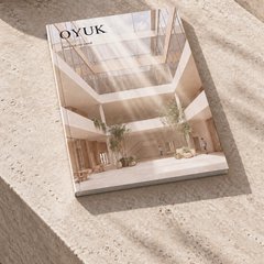 Traverten bir sedirin üzerinde duran dergi: kapakta OYUK başlığı, altında eksilterek var etmek alt başlığı ve tepeden ışık alan festival avlusunun görseli