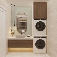 Banyo ve çamaşır alanı: traverten yan duvarlar, açık yeşil piket karolu lavabo duvarı, bronz çerçeveli oval ayna, iki sarkıt, altı aydınlatmalı ahşap lavabo dolabı ve üst üste çamaşır ve kurutma makinesi